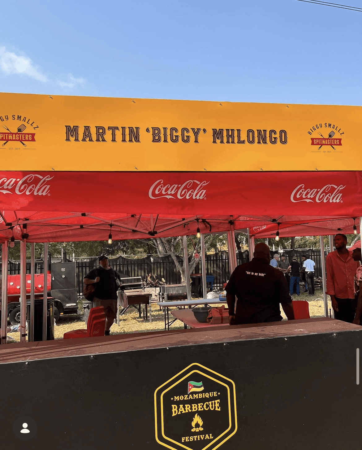 Biggy's own branded stall, his name Martin 'Biggy' Mhlongo across the top banner, the Mozambique Barbecue Festival badge below.