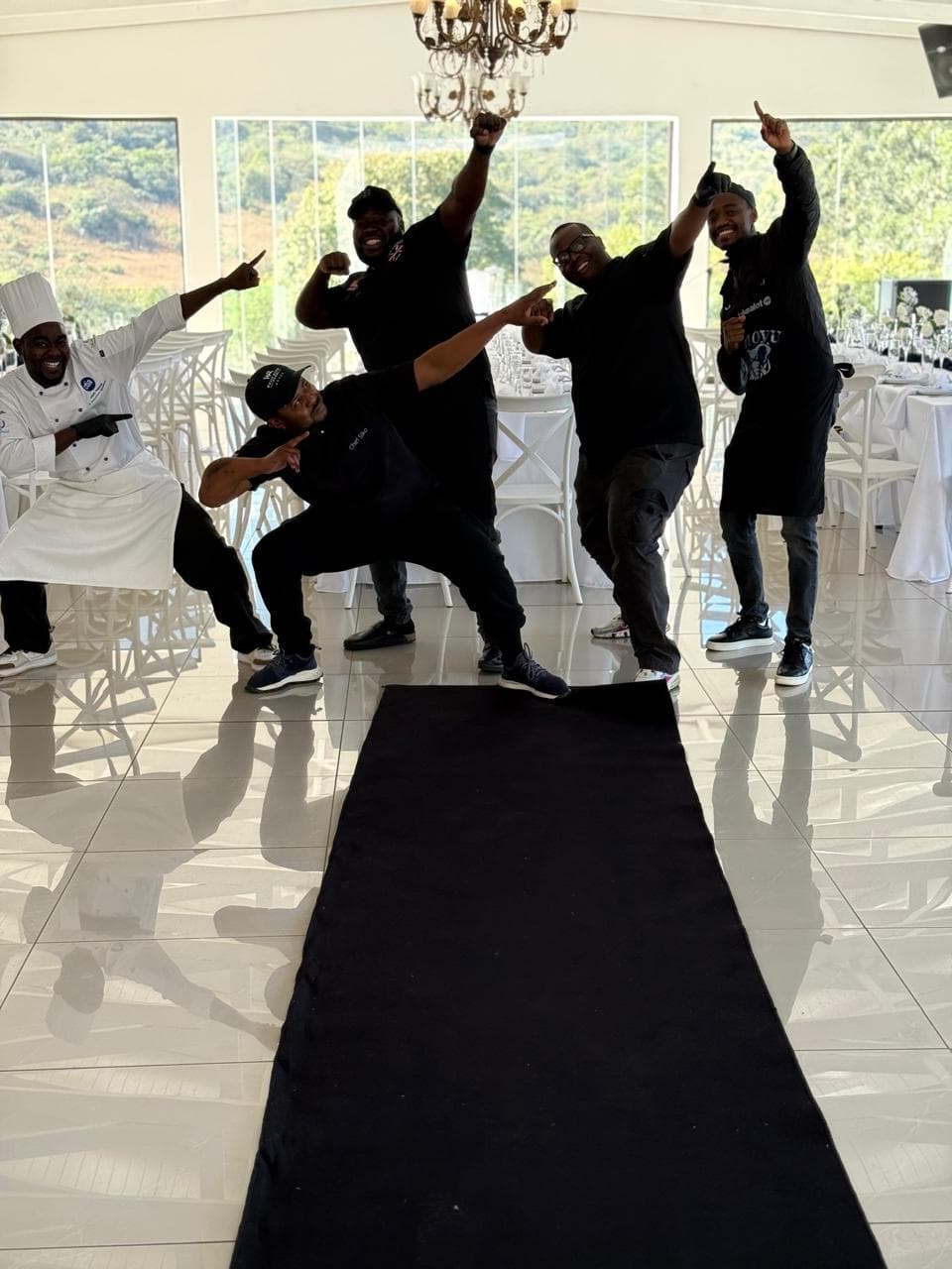 The crew celebrating together on the dance floor of a wedding venue.