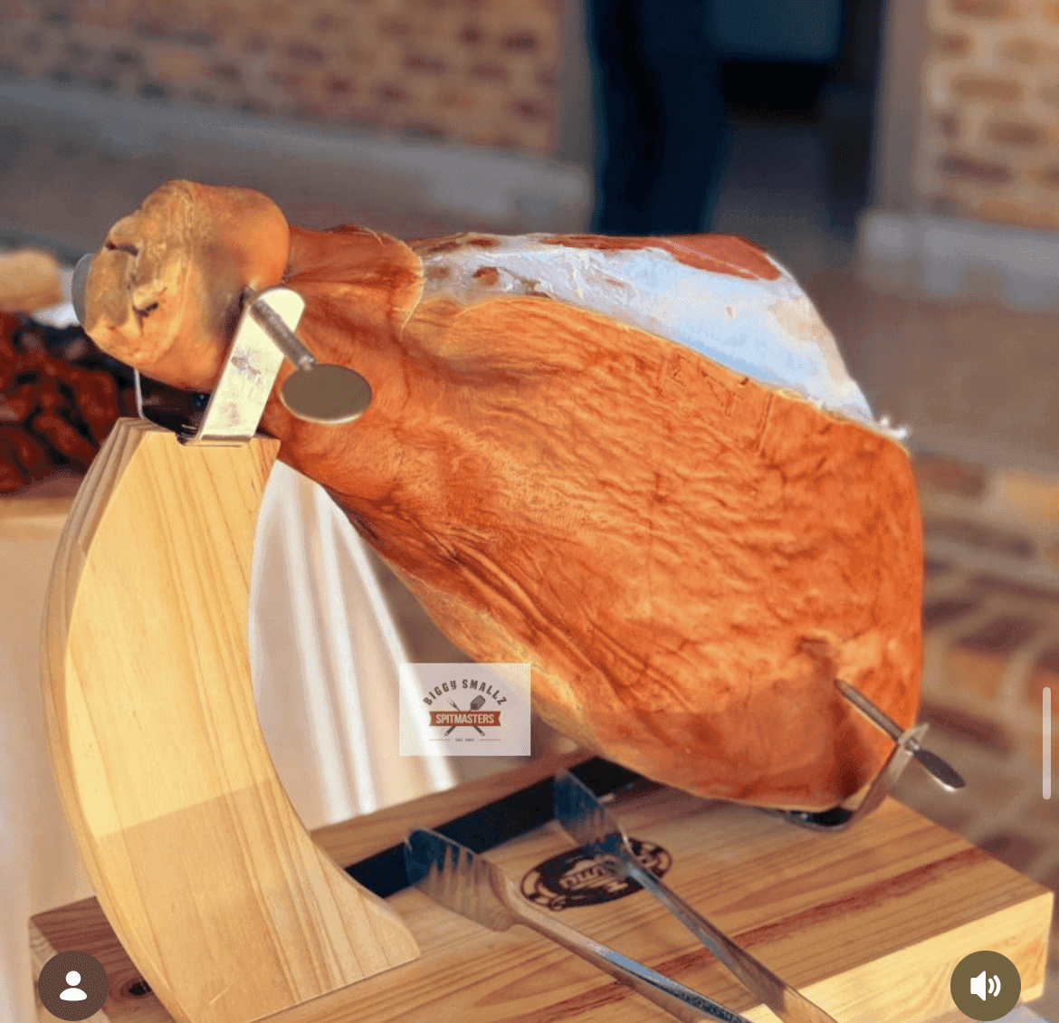 Hand-carved jamón, aged and thinly sliced, on a wooden stand.